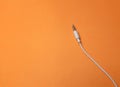 Earphones Mini Jack plug on orange  background Royalty Free Stock Photo