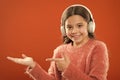 Earphones wireless modern technology. Girl child listen music wireless headphones pointing with index finger. Get music Royalty Free Stock Photo