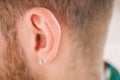 Earring in the male ear. Piercing Part of the body Royalty Free Stock Photo