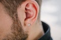 Earring in the male ear. Piercing Part of the body