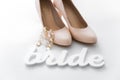 Earrings with bride shoes with word bride on the white table