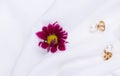 Earrings and flower on a white background