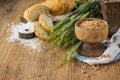 Ears of barley flour, bread on a wooden background