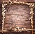 Ears of wheat made as frame on old wood. Royalty Free Stock Photo