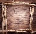 Ears of wheat made as frame on old wood. Royalty Free Stock Photo