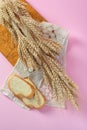 Ears of wheat and white bread rusks on a wooden board from above Royalty Free Stock Photo