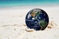 The earth on beach, including elements furnished by NASA Royalty Free Stock Photo