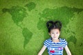 Earth day and children`s day concept with happy Asian kid relaxing on world map green lawn Royalty Free Stock Photo