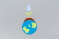 Earth Day concept. Cutted out of felt the planet Earth and soil with a watered plant sprout. Copy space. Gray background. Flat lay