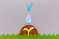 Earth Day. Cutted out of felt drop and soil with plant sprout. Gray background. Copy space. The concept of environmental