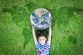 Earth day, ecological friendly and corporate social responsibility concept with kid raising world on green lawn Royalty Free Stock Photo