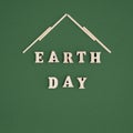 Earth Day words and symbolic roof of house on green background. Protect, preserve our home - Earth. square size, card Royalty Free Stock Photo