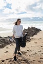 Earth day. Young female activist putting plastic bottles in a garbage bag, cleaning coastal zone, cropped, vertical shot Royalty Free Stock Photo