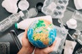 Earth drowned plastic garbage globe people hands