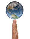 The Earth globe balances on the tip of a index finger isolated on white background. Evironmental concept. Close up image. Elements