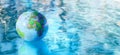 Earth globe beach ball floating on water surface Royalty Free Stock Photo