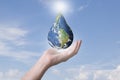 Earth globe drop shape floating in hands , Blue world globe in human hand on cloudy sky background, Energy saving , world Royalty Free Stock Photo