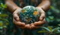 Earth globe in human hands on green natural background. World environment day concept. Royalty Free Stock Photo