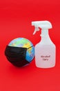 Earth globe model with black surgical mask and 70% alcohol isolated on red background. Concept: Quarantined earth. Vertical shot. Royalty Free Stock Photo