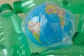 Earth globe in plastic bag among plastic bottles - Concept of ecology and stop plastic pollution Royalty Free Stock Photo