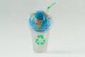 Earth globe in a plastic bag with straw on plastic glass with recycling symbol - Concept of ecology and stop plastic pollution Royalty Free Stock Photo