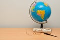 An earth globe with a scroll, glasses and a fountain pen