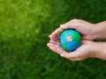 Earth in hands and green grass field background. environment sav Royalty Free Stock Photo