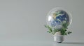 Earth, within a light bulb, is bordered by rich foliage and rocky terrain. Royalty Free Stock Photo