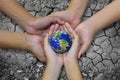 Earth planet in asian Children hand isolated on Ground arid barr