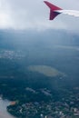 Earth in the porthole under the wing of an airplane. Flying in the fog over cities, rivers, forests Royalty Free Stock Photo