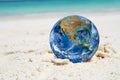 The earth on sand beach, including elements furnished by NASA Royalty Free Stock Photo