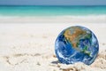 The earth on sand beach, including elements furnished by NASA Royalty Free Stock Photo