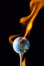 Earth Sticking with the golf ball with flame Royalty Free Stock Photo