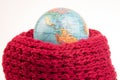 earth world globe in a warm scarf on a white background. global warming of the atmosphere. world weather