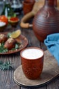 Earthen glass with cold buttermilk ayran or kefir. Close up on a wooden table. A delicious and healthy drink Ayran in Royalty Free Stock Photo