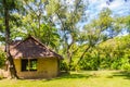 Earthen house under shade of trees. An earth house, also known as earth berm, earth sheltered home, or eco-house is an architectur