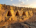 Earthen wall with triangular openings in a desert landscape under sunlight Royalty Free Stock Photo