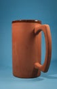 Earthenware jug with blue background (vertical) with interesting light. Concept of wellness, freshness, warm, etc.