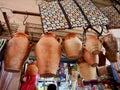 Earthenware tanjia pots hanging from shop in Marrakech souk, Morocco.
