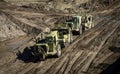 Earthmoving vehicles following each other while scrapping dirt as part of a grading project Royalty Free Stock Photo