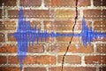 Earthquake wave graph concept with cracked and damaged brick wall