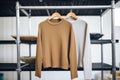 earthtoned rollneck sweaters on an industrial metal rack