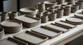Handcrafted Clay Tableware Collection of Mugs, Plates and Dishes in Earthy Tones Displayed on Bright Worktop Surface in Royalty Free Stock Photo
