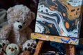 easel with abstract paint splotches, teddy bear nearby Royalty Free Stock Photo