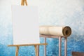 Easel background with a white sheet and a roll of paper