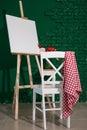 Easel with canvas and chair in artist's workshop Royalty Free Stock Photo