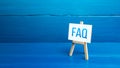 Easel with FAQ frequently asked questions. Available answers to overcome difficulties and misunderstandings. Guide, navigation. Royalty Free Stock Photo