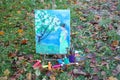 Easel with paints and painting on canvas in autumn park Royalty Free Stock Photo