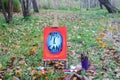 Easel with paints and painting on canvas in autumn park Royalty Free Stock Photo