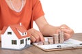 The East Asian old man is placing increasing dollar coins and a small house model beside him Royalty Free Stock Photo